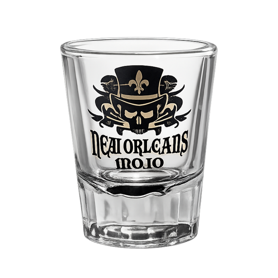 Clear shot glass with black and gold design and text on a white background