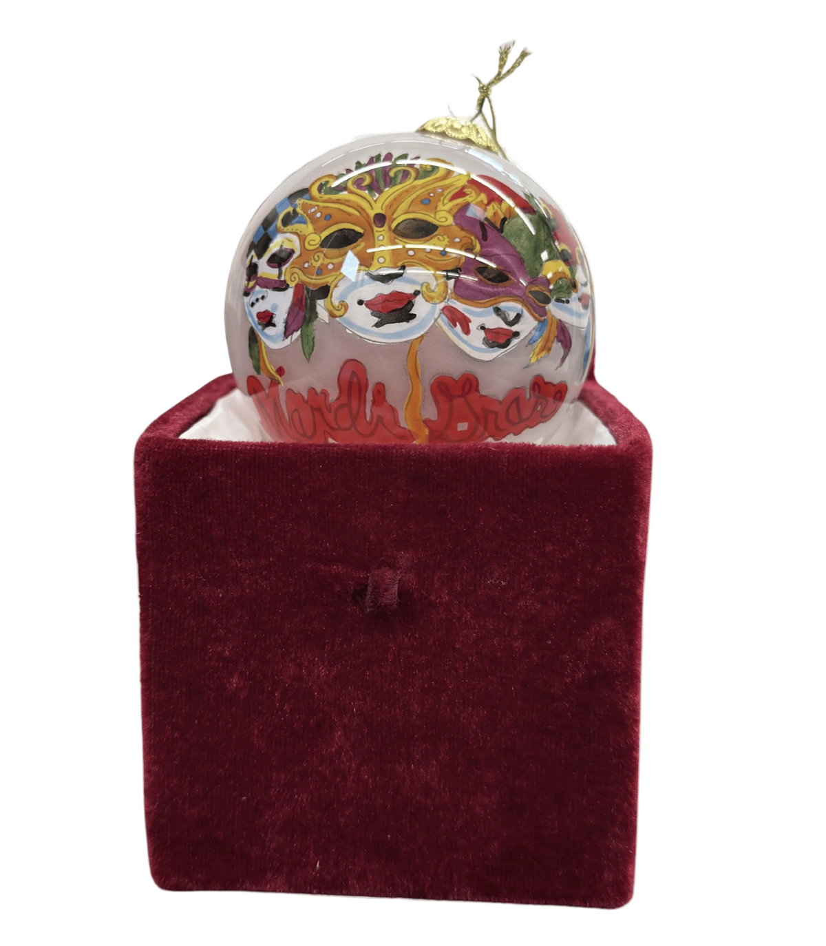 Decorative ornament with a colorful design on top of a red velvet box against a white background