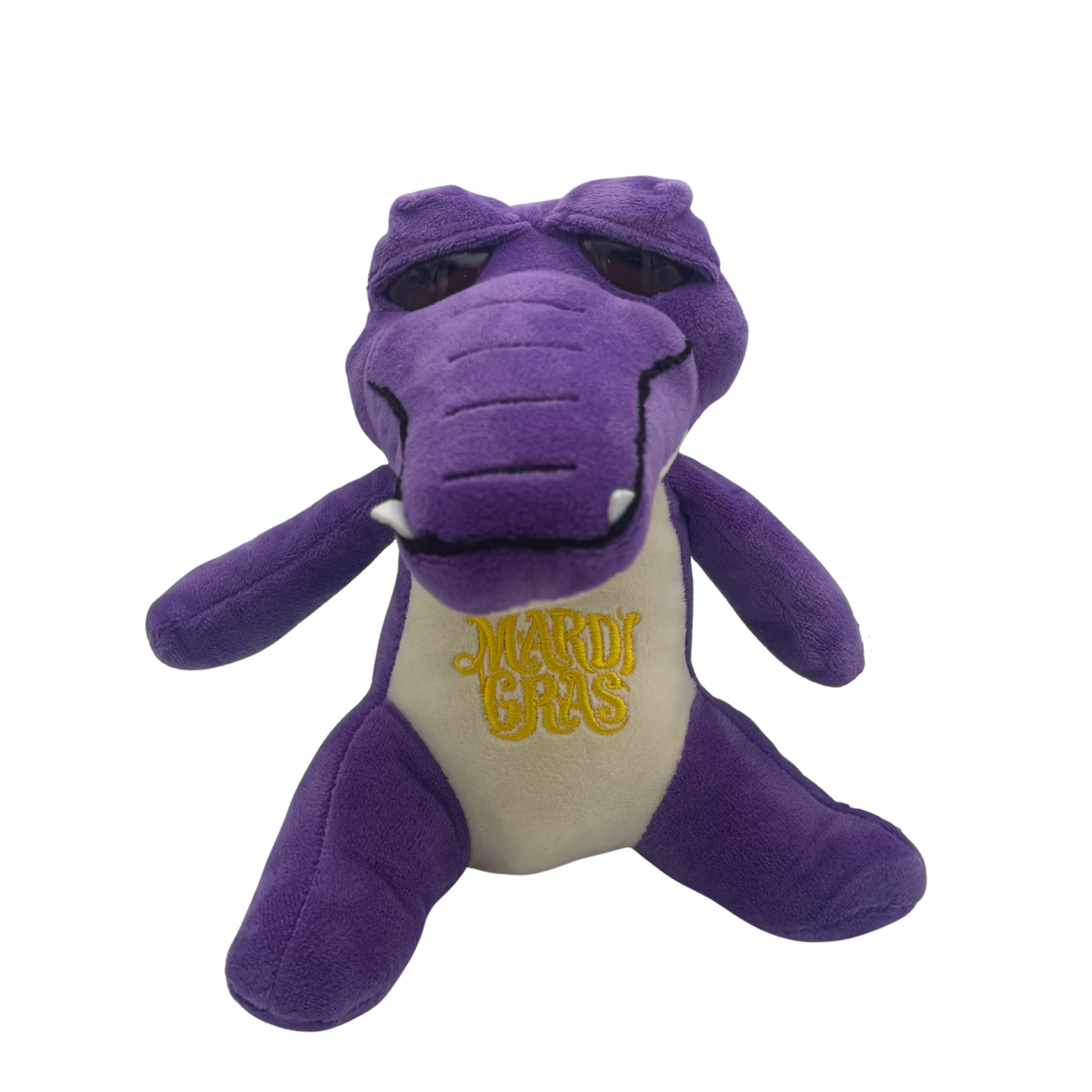 A purple plush alligator toy with a cream-colored belly embroidered with 'Mardi Gras' in yellow, shown against a plain white background.