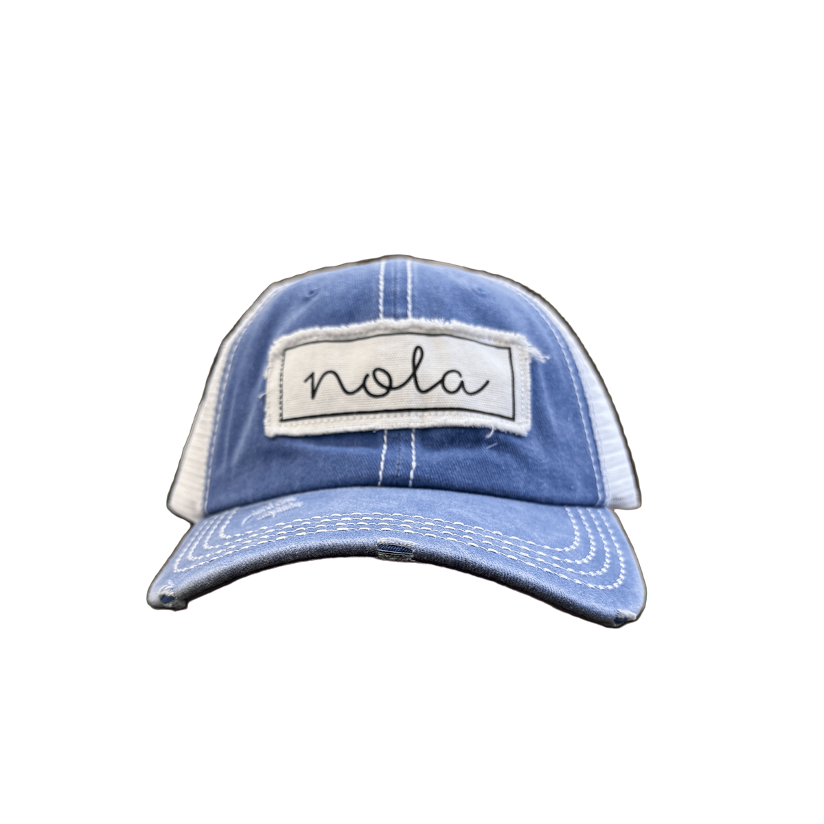 Blue and white cap with 'nola' patch on a green background