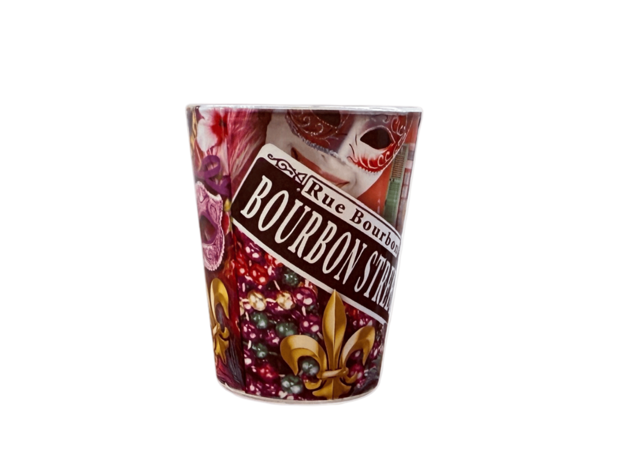 A novelty shot glass featuring a Mardi Gras themed design with masks, beads, fleur-de-lis, and a banner reading 'Rue Bourbon BOURBON STREET'.