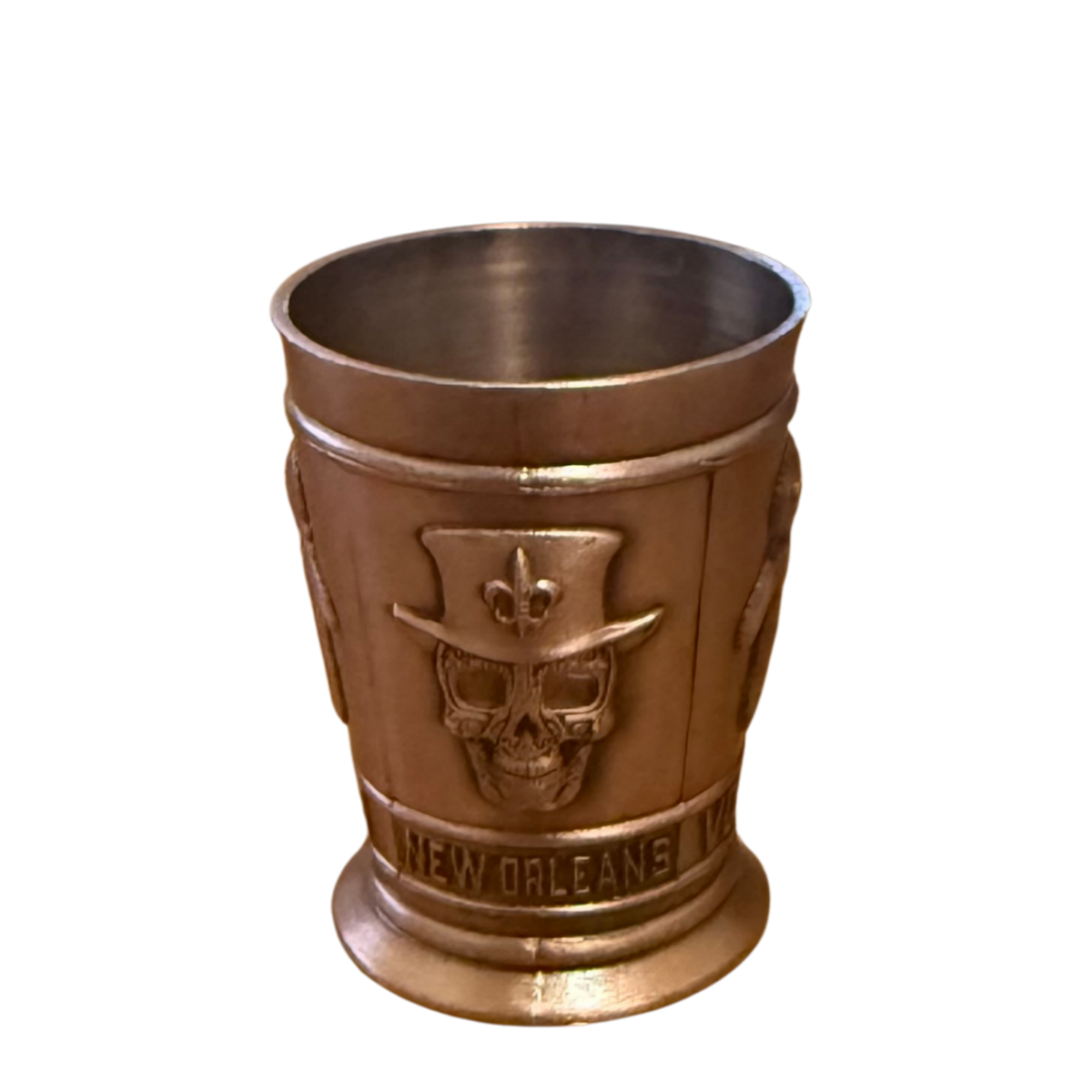 Bronze-colored shot with skull design on a white background