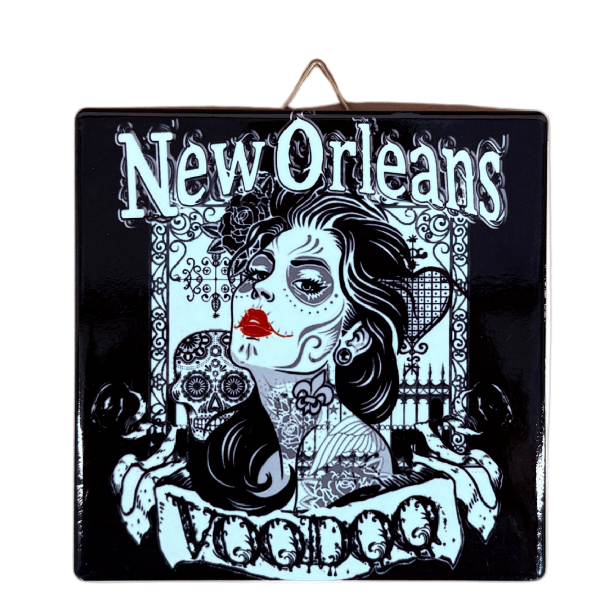 A square black decorative ceramic tile featuring a stylized Day of the Dead illustration with the words 'New Orleans' at the top and 'Voodoo' at the bottom. The design shows a woman's face with red lips, skulls, floral motifs, and a hanging loop at the top, photographed on a plain white background.