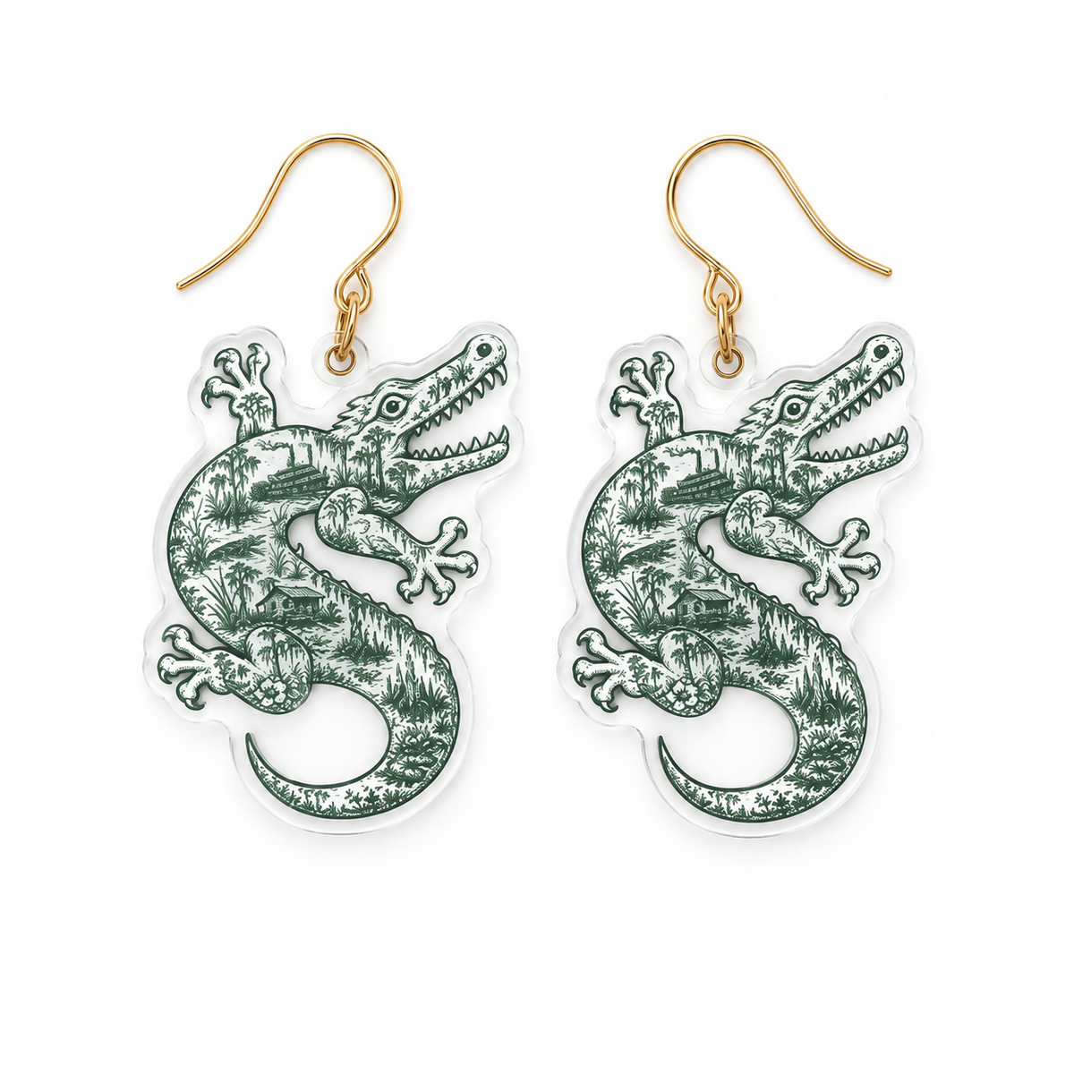 A pair of dangling earrings featuring green alligator illustrations on clear acrylic pendants with gold fishhook wires, shown against a plain white background.